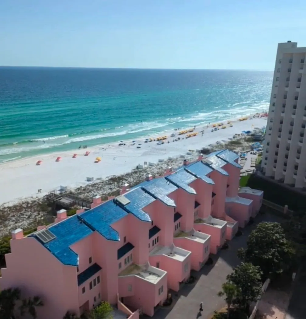 Aerial photograph of the Okaloosa County coastline showing Gulf water, white sand and condominium rooftops.